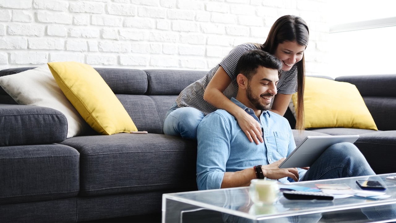 a couple using a tablet together on sofa, image used for HSBC Mauritius Online Banking