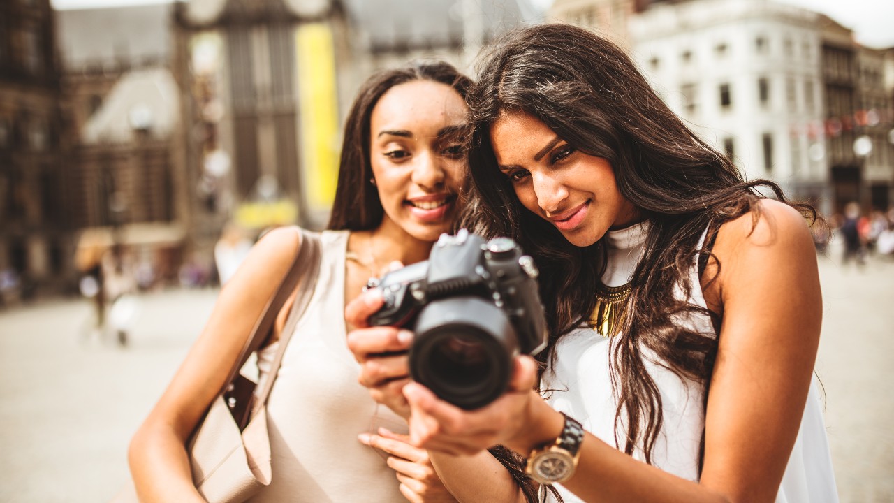 Two female travellers looking at pictures on camera